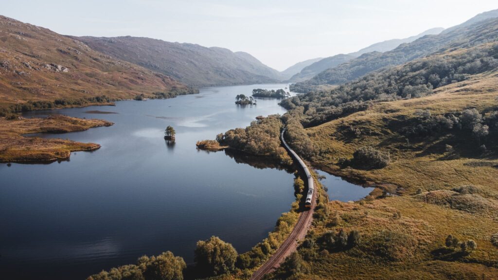 Vue panoramique d’un loch écossais entouré de montagnes, représentant les itinéraires de voyage à travers les Highlands.